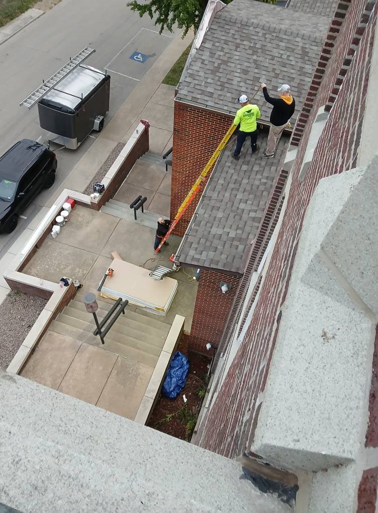 Crew at work on a commercial roof, seen from the tower above